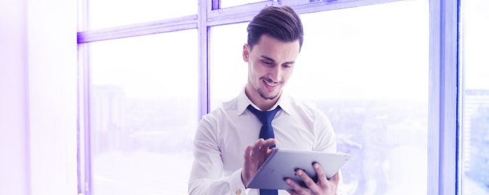 hombre usando una tablet sentado cerca de la ventana